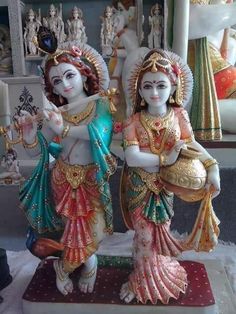 two statues of hindu deities are standing next to each other