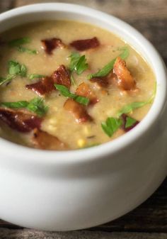 a white bowl filled with soup on top of a wooden table