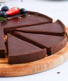 a chocolate tart is cut into slices on a cutting board