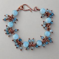 a bracelet with blue beads and copper wire on a gray background, it looks like something from the movie star wars