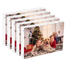 three children and a dog laying on the floor in front of a christmas tree with presents