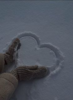 a teddy bear laying in the snow with a heart drawn on it's side