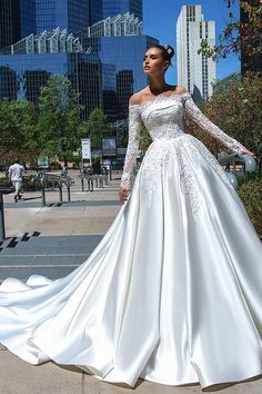 a woman in a wedding dress standing on the sidewalk