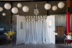 an open room with white curtains and hanging lights