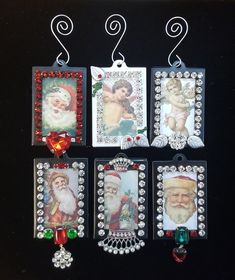 six christmas cards hanging from hooks on a black surface with beads and charms attached to them