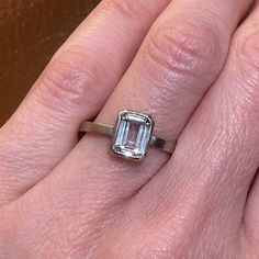 a woman's hand with a ring on it and an emerald stone in the middle