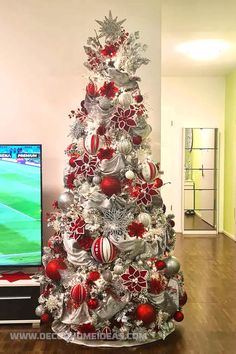 a decorated christmas tree in front of a television