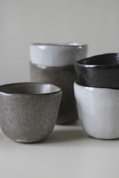 four bowls sitting on top of a table next to each other in different shapes and sizes