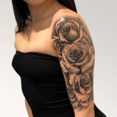 a woman with a black and grey rose tattoo on her arm