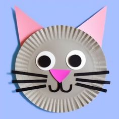 a paper plate with a cat's face cut out to look like it is smiling