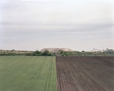 an aerial view of a large field with trees in the distance