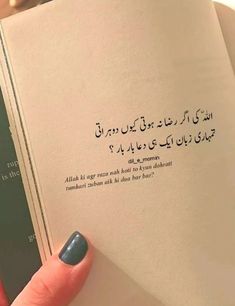 a person holding an open book with arabic writing on the cover and in their left hand