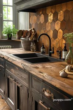 a kitchen with wooden counter tops and black sink in the center, surrounded by potted plants