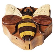 a wooden box with a bee on it's side and two bees in the middle