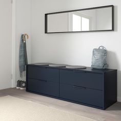 a blue dresser sitting next to a mirror and coat rack