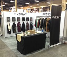 a row of racks with coats on display at a fashion show in an indoor building