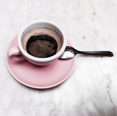 a cup of coffee is sitting on a saucer with a spoon next to it