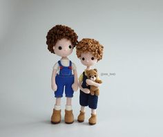 two crocheted dolls standing next to each other with one holding a teddy bear