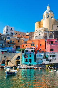 boats are docked in the water next to colorful buildings