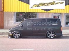 a van is parked in front of a building with yellow and black stripes on it