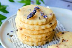 a stack of lavender cookies sitting on top of a white plate