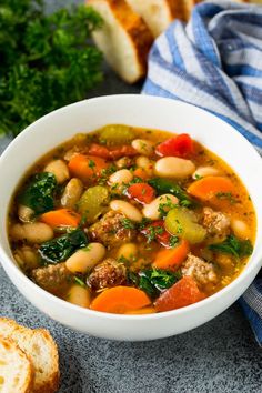 a bowl of white bean soup with bread on the side and text overlay reading tuscann white bean soup