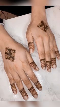 two hands with henna tattoos on them