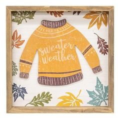 a wooden frame with an image of a yellow sweater on it and leaves around it