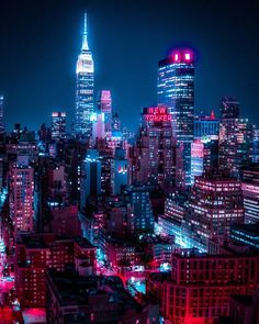 the city skyline is lit up in blue and red lights at night, as well as skyscrapers