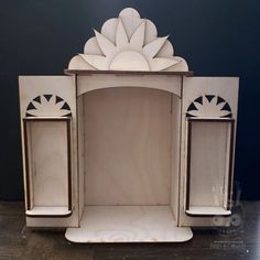 a white wooden cabinet with an intricate design on the front and side doors, sitting on a hard wood floor