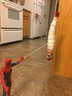 a spider - man is trying to pull someone out of the kitchen