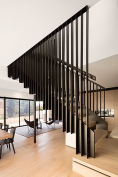 a wooden table sitting under a stair case next to a glass wall with black railings