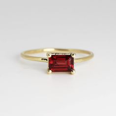 This beautiful Emerald Cut Garnet Gold Ring was handmade in Melt'm Jewelry Design Studio in California using 14k solid yellow gold band and 6x4mm emerald cut natural garnet stone. Garnet is featuring in 14k gold prong setting. DETAILS ABOUT THE RING, MATERIAL AND STONES Ring Band: 14K solid gold Ring Band size: 1 mm thick Gemstone: Garnet Garnet size: 6mm x 4mm emerald cut It is a great birthday gift for your special ones whose birthday are in January, since Garnet is January birthstone. This so Garnet Gold Ring, Gold Ring Band, Jewelry Design Studio, January Birthstone Rings, Garnet Engagement Ring, Red Garnet Ring, Garnet And Gold, Solid Gold Ring, January Birthstone