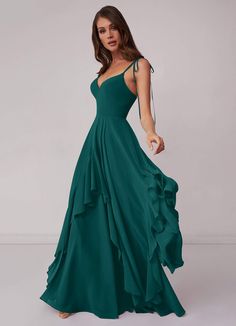 a woman in a long green dress with ruffles on the bottom and back