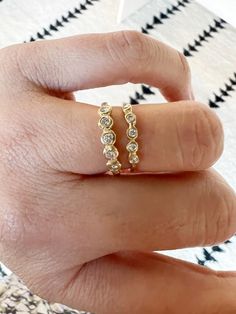 a woman's hand wearing a gold ring with three small diamonds on the side