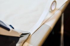 a close up view of a bed with sheets and tape on the edge of it