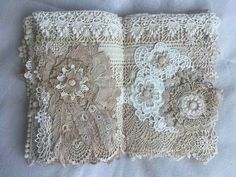 an open book with lace and flowers on it