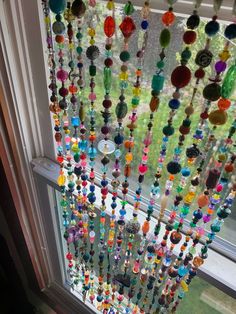 colorful beads hanging from the side of a window