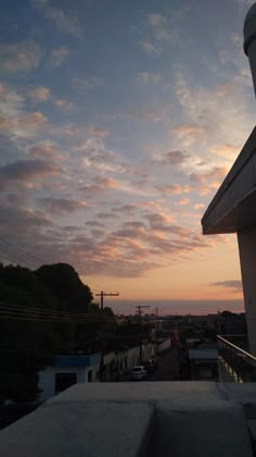 the sun is setting over some buildings and trees