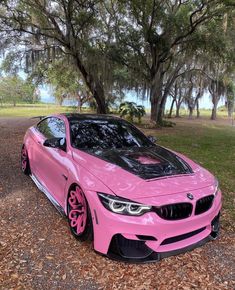 a pink car is parked in the grass