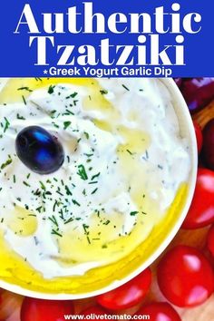 a bowl filled with greek yogurt garlic dip surrounded by tomatoes and olives