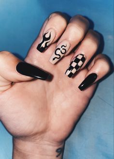 a woman's hand with black and white nail art on it, holding up her fingers