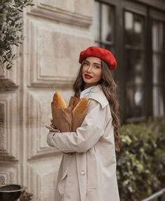 a woman in a red hat is holding some bread