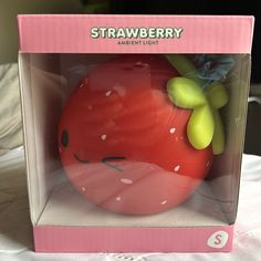 a strawberry in a pink box on a table