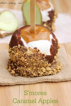 an apple covered in caramel and whipped cream on top of a green napkin with a toothpick sticking out of it