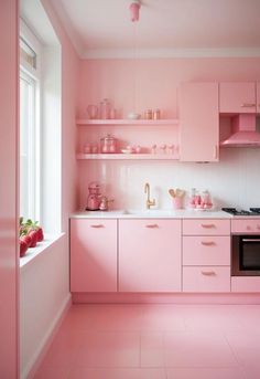 a kitchen with pink cabinets and white counter tops