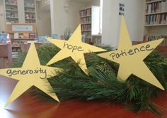 three stars with words written on them sitting on top of a wooden table in front of bookshelves