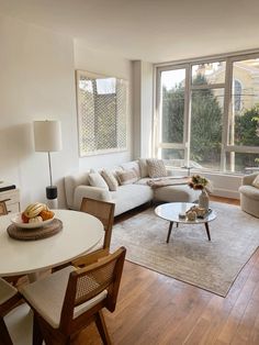 a living room filled with furniture next to a large window covered in lots of windows