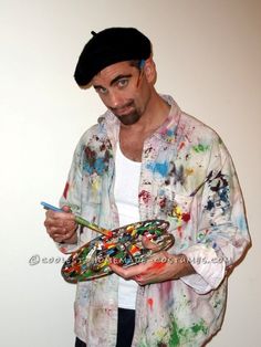 a man holding a paintbrush and palette in his hands