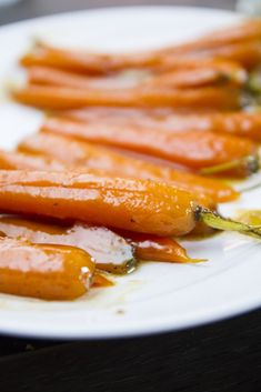 some carrots are on a white plate with sauce